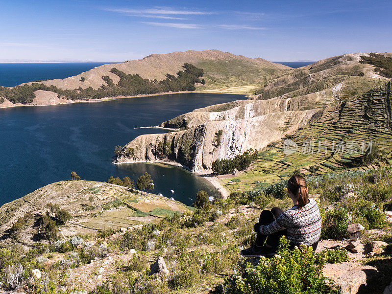 年轻的白人女性妇女坐在欣赏美丽的风景与山，山脉，湖的titicaca isla del sol，太阳岛，科帕卡巴纳，玻利维亚